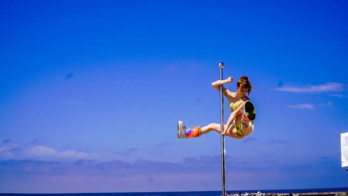Closeup of dancer doing the splits in mid air outside on all star stages portable stripper pole 2-2