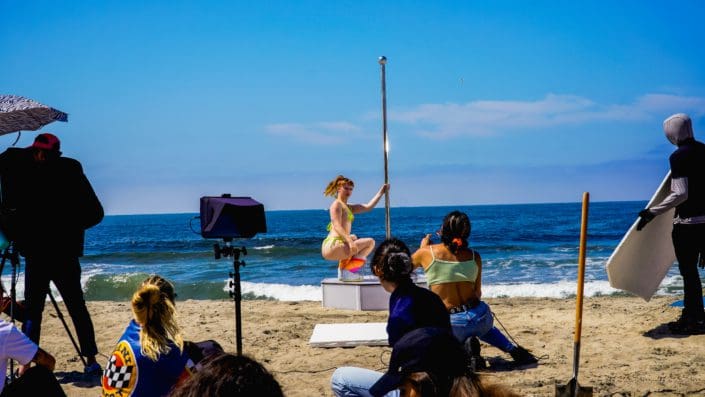 Model poses on all star stages dance pole on beach in front of camera crew-2 Model poses on all star stages dance pole on beach in front of camera crew-2