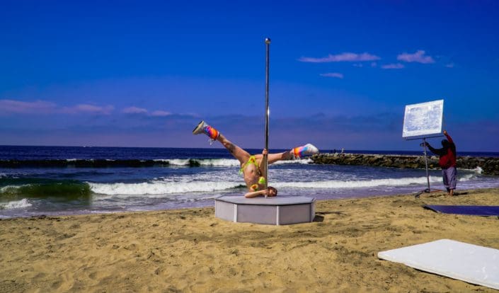 Model poses upside down on all star stages portable dance pole on the beach-2