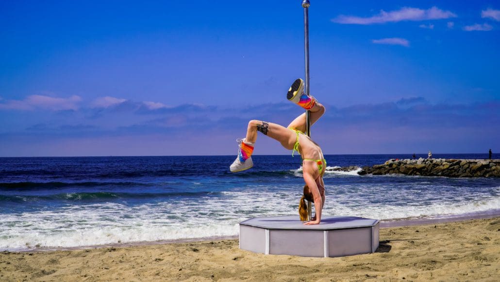 Model poses upside down on all star stages portable dance pole on the beach 4-2 Model poses upside down on all star stages portable dance pole on the beach 4-2