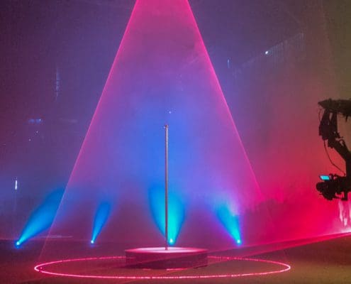 pink and blue laser lights on set over all star stages portable stripper pole stage 1000px
