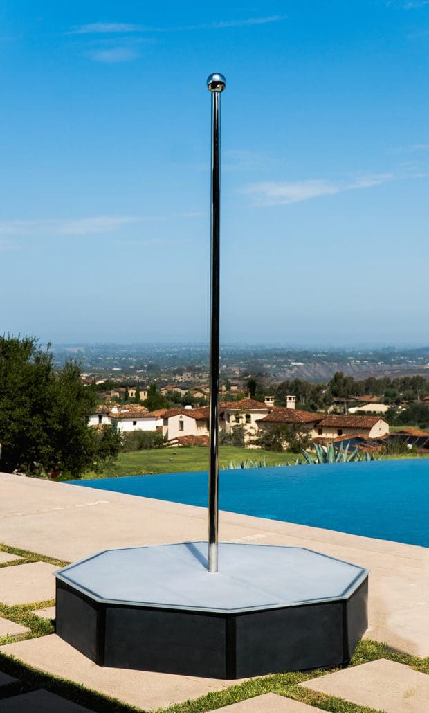 closeup 5x5 octagon portable stage with frosted acrylic top matte black sides and 9 ft dance pole outside with pool and view in background 2