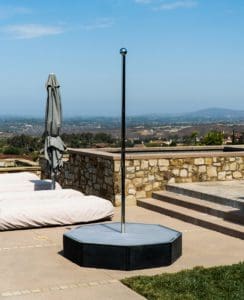 gotham matte black portable ocatgon stage and ceiling free dance pole in backyard on concrete with orange county view