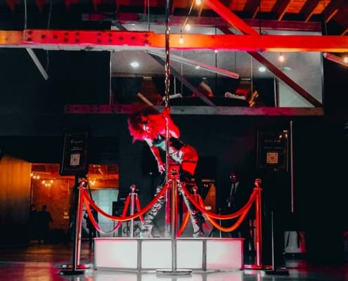 dancer performs on an all star stages x spinning portable dance pole and octagon stage abstract