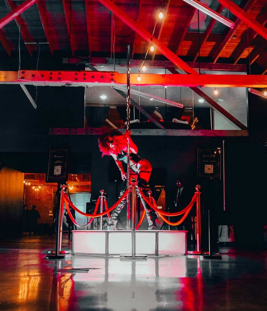 dancer performs on an all star stages x spinning portable dance pole and octagon stage abstract