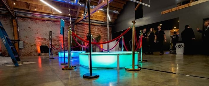 dual all star stages x stage spinners glow orb octagon stage and spinning dance pole led in blue and turquoise at indoor event