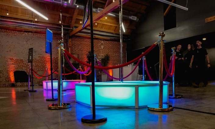 dual all star stages x stage spinners glow orb octagon stage and spinning dance pole led in pink and turquoise at indoor event