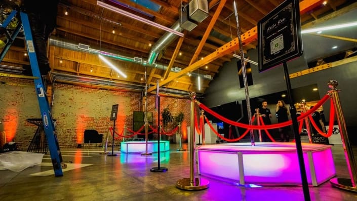 dual all star stages x stage spinners glow orb octagon stage and spinning dance pole led multi colorand pink at indoor event