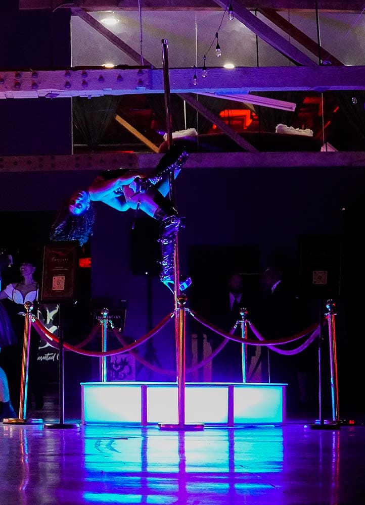 model performs on an all star stages x spinning dance pole and octagon glow stage in blue